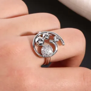 Detailopname van een zilveren ring met micro-pavé zirkonia bollen en hol ontwerp