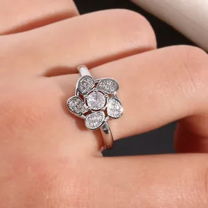 Close-up of a five-petal flower ring with micro-paved cubic zirconia on a female finger