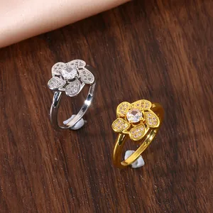 Detailed view of gold and silver five-petal flower rings with micro-pave cubic zirconia