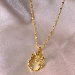 Macro view of a gold-plated money bag pendant necklace with opal stone and zircons