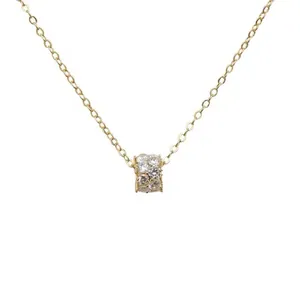 Collier cylindre doré élégant avec micro-pavage de zircons sur un fond blanc neutre