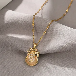 Close-up of a gold money bag pendant with champagne cat eye stone and cubic zirconia dollar sign