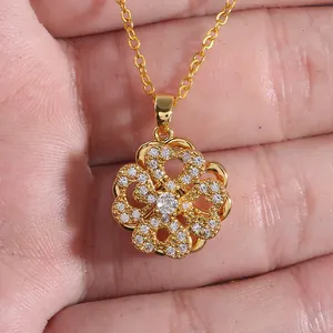 Detailed view of rotating gold clover pendant with sparkling micro-inlaid zircons