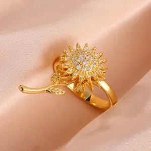 Anillo de girasol dorado con pétalos giratorios y circonitas sobre fondo de terciopelo beige