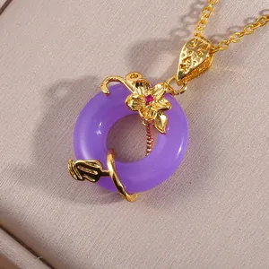 Macro shot of purple gemstone pendant with gold floral vine filigree and zircon details