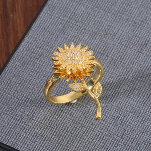 Detalle macro del anillo giratorio de girasol con circonitas y diseño de hoja dorada