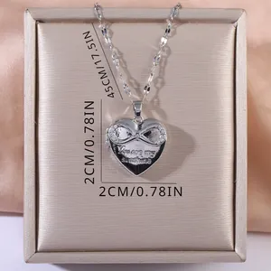 Gros plan d'un collier médaillon coeur argenté avec You Are My Sunshine et signe infini