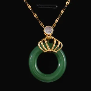 Golden crown necklace with green circle pendant and zircon inlay on black display stand