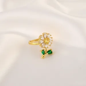 Detail view of sunflower ring featuring yellow gemstone and green leaf accents
