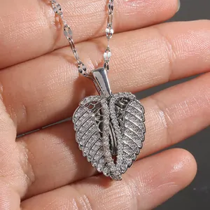 Silberne Feder-Herz-Medaillon-Halskette mit Zirkonia-Inlay in der Hand gehalten
