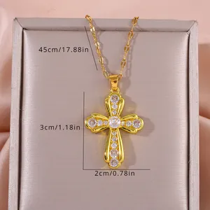 Detail view of gold cross pendant with cubic zirconia stones showing 3cm by 2cm dimensions