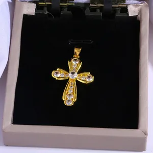 Gold hollow cross pendant with sparkling zircons on elegant black velvet background