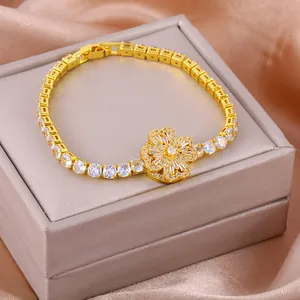 Detail of a rotating golden clover bracelet with zircon stones on silk fabric