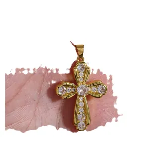 Luxurious gold cross pendant necklace featuring micro-set cubic zirconia on a model hand