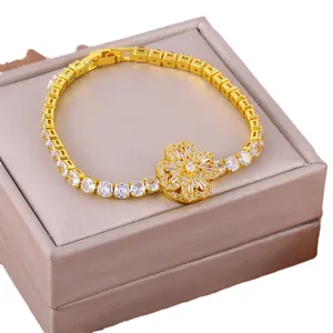Gold rotating clover bracelet with copper micro-set cubic zirconia on a jewelry box