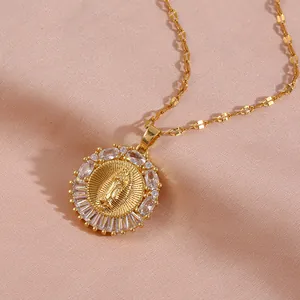 Gold-plated Virgin Mary pendant necklace with sparkling cubic zirconia on soft fabric