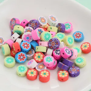 Perles colorées en pâte polymère florale pour bijoux DIY dans un bol en céramique blanc