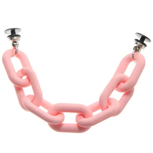 Detailed view of matte pink acrylic chain accessory with black fasteners for clogs