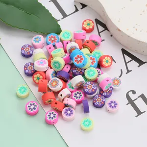 Gros plan de perles plates en argile colorées avec motifs floraux pour bijoux faits main