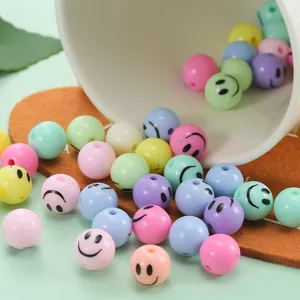 Colorful 12mm smiley face round acrylic beads pouring from a cup for DIY jewelry making