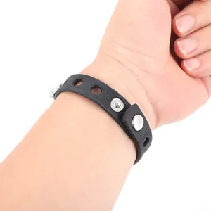 Detail of a matte black silicone strap featuring adjustable metal snap fasteners and four holes