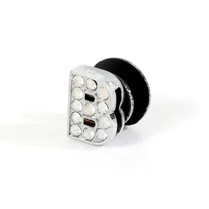 Detailed view of a silver-toned metal B-letter shoe charm with sparkling rhinestones