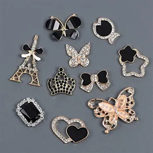 Detalle de accesorios metálicos para calzado con diseños de mariposas y coronas