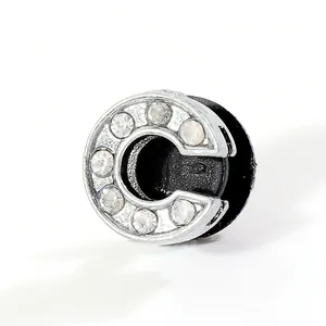 Detail of silver letter C shoe charm with rhinestones and black round fixing base