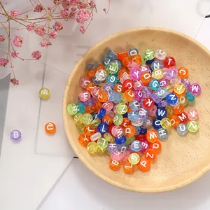 Detailopname van gekleurde acryl letterkralen voor DIY-sieraden in een houten kom