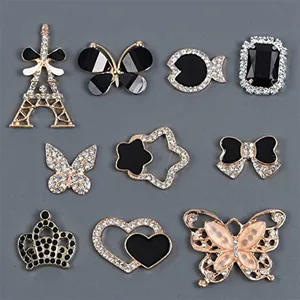 Detalle de adornos para zapatos en aleación dorada con esmalte negro y pedrería