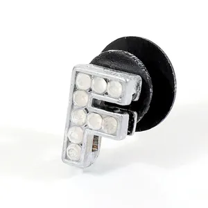 Detail view of crystal rhinestone letter F charm with black plug for clog shoes
