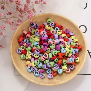 Macro-opname van gekleurde hartvormige letterkralen voor DIY sieraden in houten kom