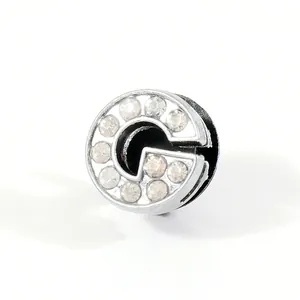 Macro shot of silver letter G shoe charm with sparkling rhinestones for clogs decoration