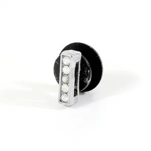 Macro detail of silver-tone rectangle stud earring with five sparkling rhinestones