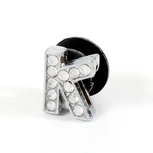 Detailed view of silver letter R shoe charm with sparkling rhinestones and black back clasp