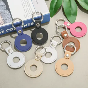 Zeven kleurrijke leren hoesjes voor AirTag met sleutelhangers op grijze ondergrond