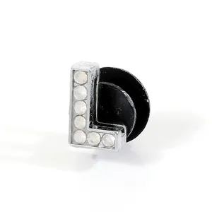 Detailed view of silver letter L charm with rhinestones and black rubber backing
