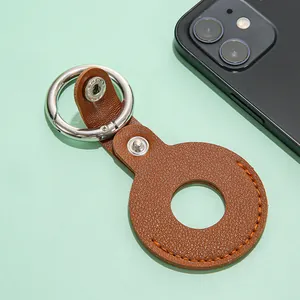 Macro-opname van bruine AirTag-hoes van generfd leer met zilveren metalen ringclasp