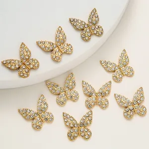 Detalle de nueve dijes de mariposa dorados con brillantes diamantes de imitación