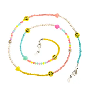Dettagli di perle colorate e ciondoli a forma di smiley su una catena per occhiali