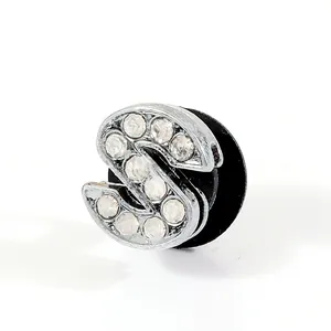 Macro shot of silver letter S shoe charm with sparkling rhinestones for clogs