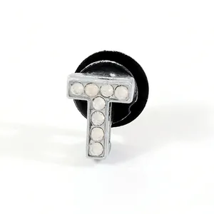Close-up of letter T shoe charm with sparkling rhinestones and black secure back plug