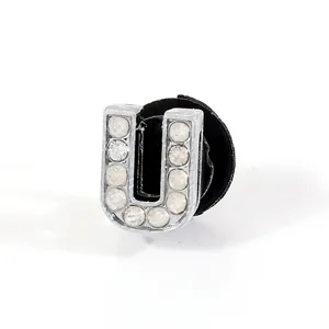 Macro detail of U-shaped silver rhinestone shoe charm with black back buckle for clogs