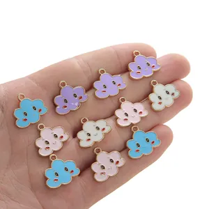 Colgantes de nubes sonrientes de colores en la mano mostrando tamaño y detalles DIY