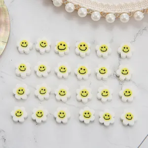 Perles fleurs sourire en pâte polymère pour bijoux DIY disposées en matrice soignée