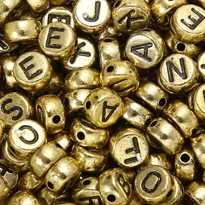 Macro di perline dorate con lettere per creazione di gioielli fai-da-te e incisioni
