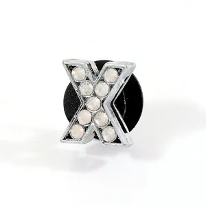 Close-up of letter X silver metal shoe charm with white rhinestones for clog decoration