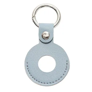 Macro-opname van lichtblauwe lederen trackerhouder met kiezeltextuur en metalen ring