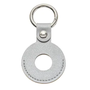 Detail van zilveren lederen AirTag-houder met getextureerde korrel en springring