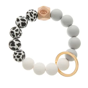Close-up of silicone beads and a hexagonal wooden bead with eye symbol on gold ring